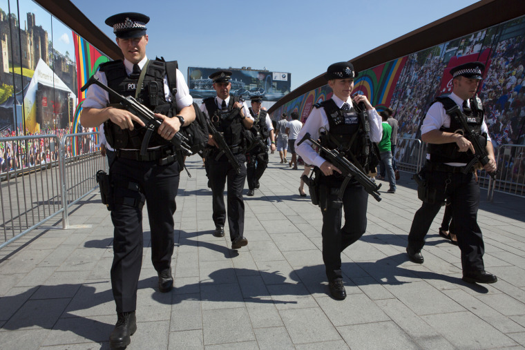 Image: Members of the Metropolitan Police cross the bridge connecting Stratford Station to Westfield Shopping Center near the Olympic Park in London.