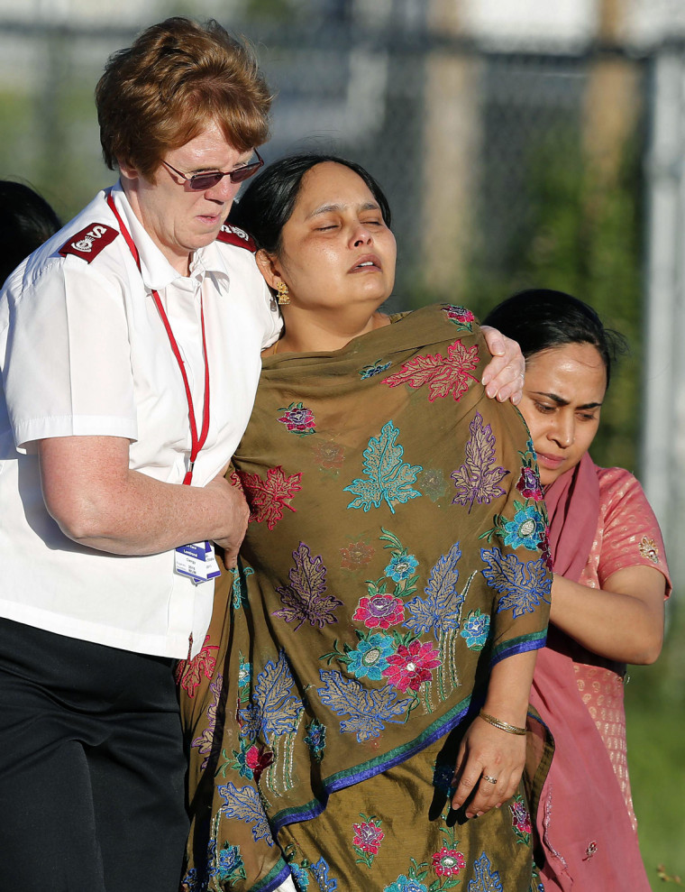 Image: A distraught women is helped to a car outside of the Sikh temple in Oak Creek, Wisconsin