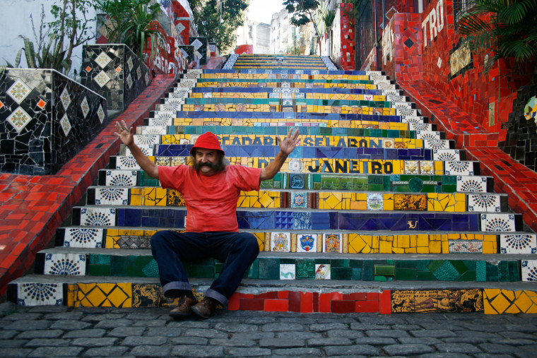Image: Artist Jorge Selaron poses while sitting on the staircase he created in Rio de Janeiro
