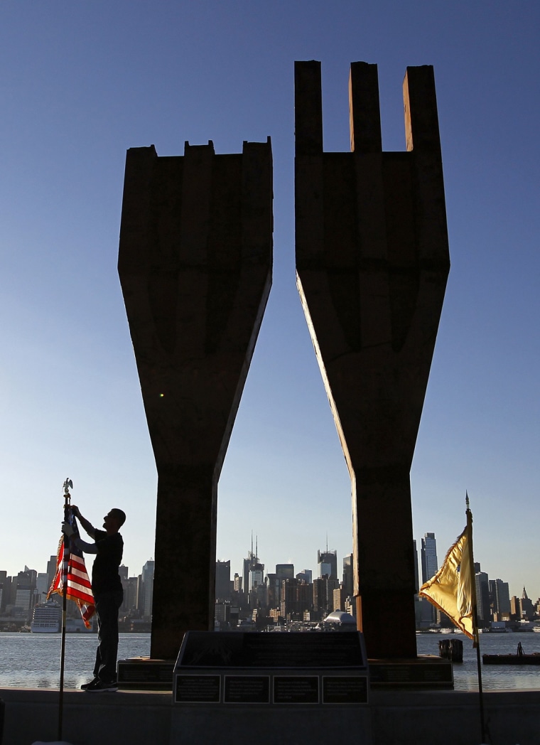 Image: Jeremy Hamilton places a U.S. flag next to a 9/11 memorial in Weehawken, New Jersey