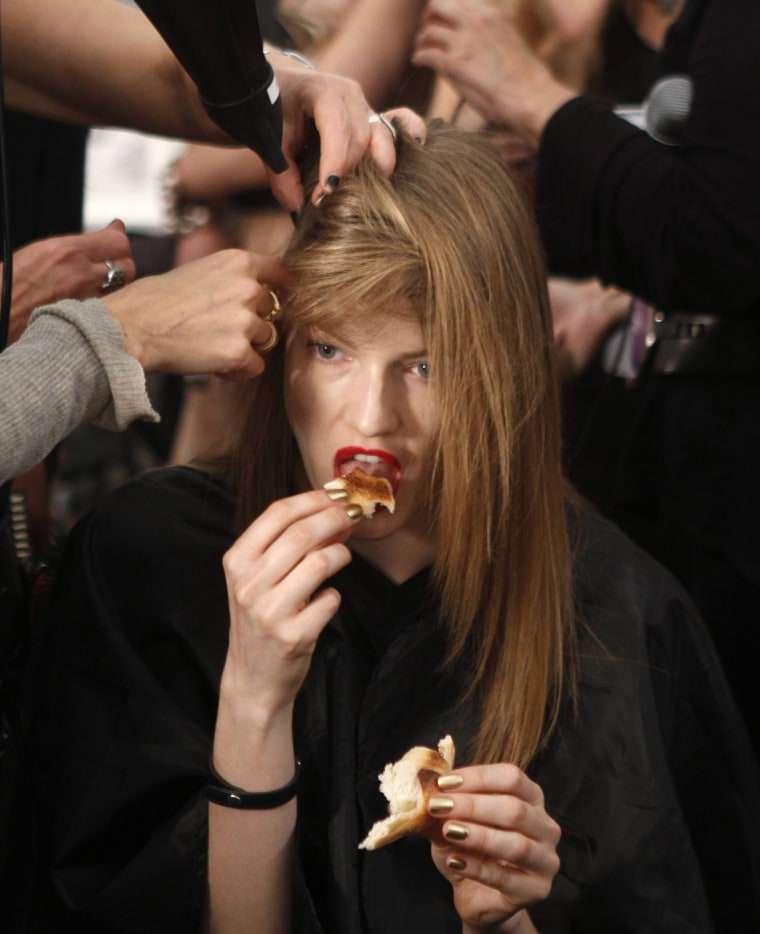 Image: A model eats backstage before the Carlos Miele Spring/Summer 2013 collection show at New York Fashion Week