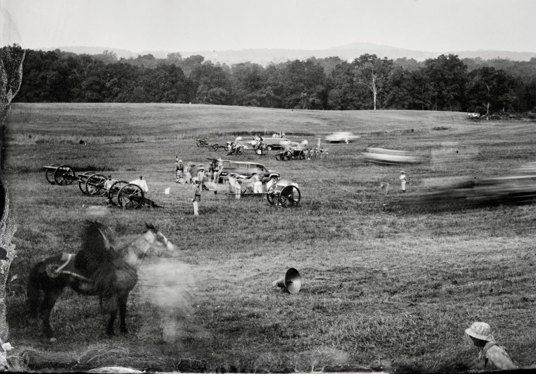 MM8046 - Civil War Sketches. Gettysburg reinactment on the battle field with trucks and speakers in foreground announcing historical account of the battle.