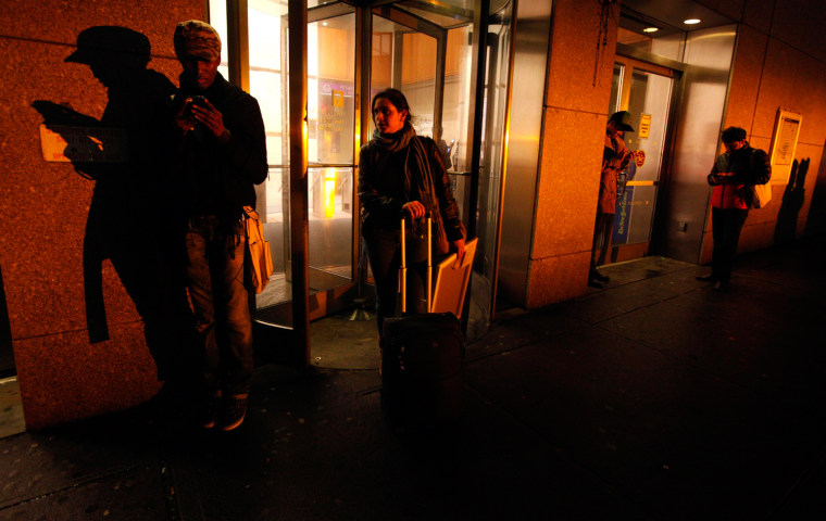 Image: People congregate in front of a building that still has wireless internet access in the aftermath of Hurricane Sandy in New York