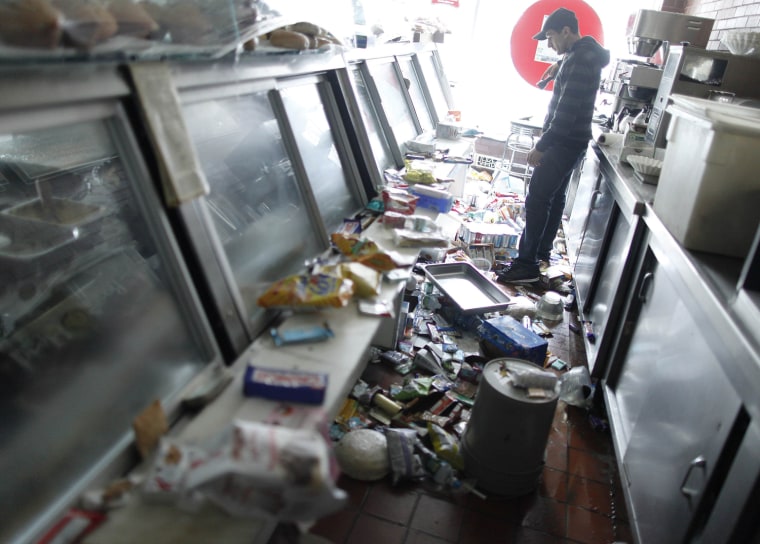 Image: Rod Zindani surveys the damage to his Best Of New York Food Deli in the aftermath of Hurricane Sandy in New York