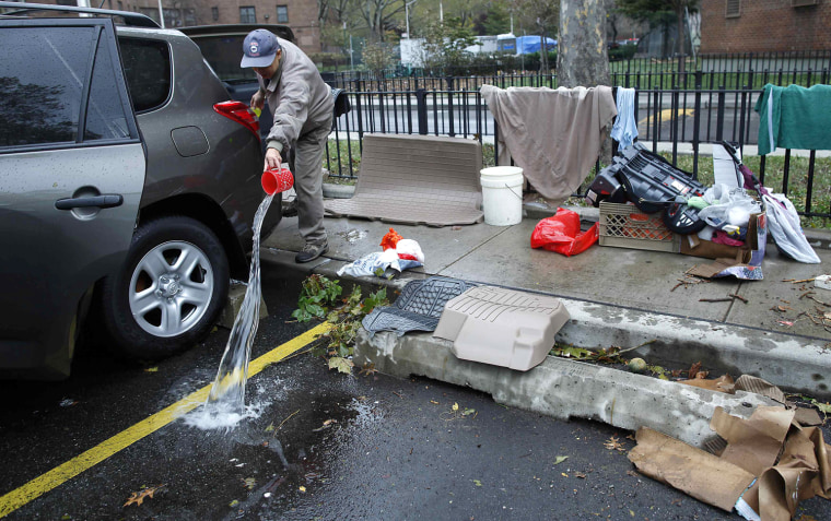 Image: A man bails out his car that got flooded in the aftermath of Hurricane Sandy in New York