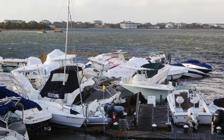 Image: Boats piled up by storm surge and the high tide lie in a pile at a marina in East Quogue