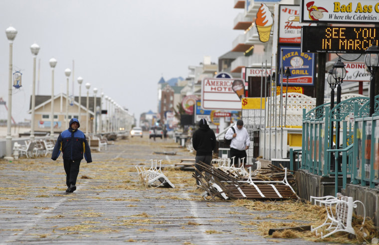Image: Residents walk by debris on the boardwalk after Hurricane Sandy in Ocean City, Maryland