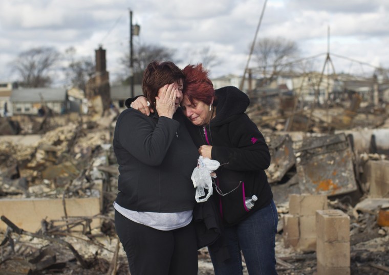 Image: Neighbors Lucille Dwyer and Linda Strong embrace after looking through the wreckage of their homes devastated by fire and the effects of Hurricane Sandy in the Breezy Point section of the Queens borough of New York