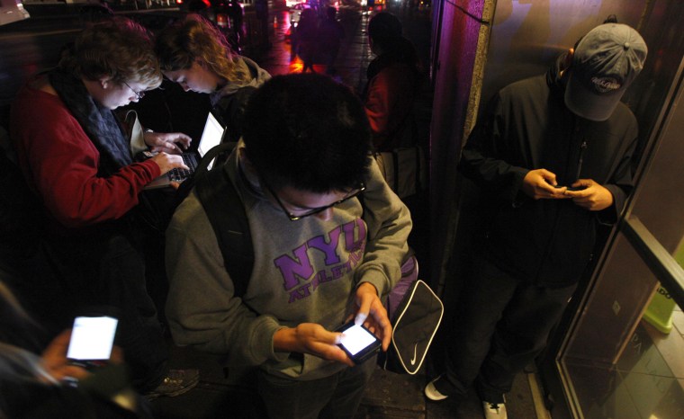 Image: People congregate in front of a building that still has wireless internet access in the aftermath of Hurricane Sandy in New York