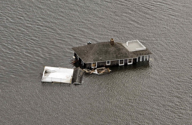 Image: A house floats in the bay after it was washed from its foundation during Hurricane Sandy in Manotoloking