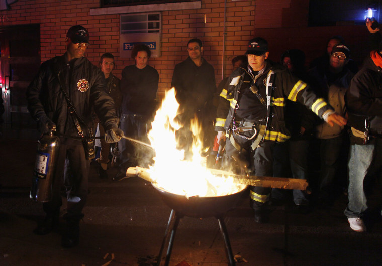 Image: Members of fire department extinguish campfire built by people in the aftermath of Hurricane Sandy in New York