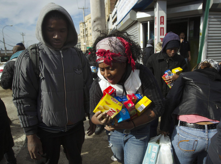 Image: People scramble for food and supplies being handed outside a grocery store damaged by Hurricane Sandy in the Rockaways section of the Queens borough of New York