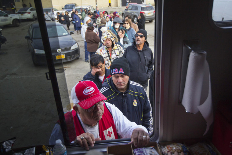 Image: People wait in line to receive food donations from the American Red Cross in Long Beach, New York