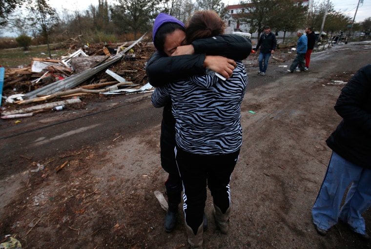 Image: Dulce Espino and Viridiana Cruz weep as they embrace along Cedar Grove Avenue in their neighborhood where many houses were completely destroyed by storm surge flooding from Hurricane Sandy