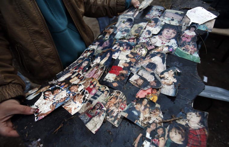 Image: Vanessa Martinez holds remains of photographs of her family outside her destroyed house on Cedar Grove Avenue in her neighborhood where many houses were completely destroyed by storm surge flooding from Hurricane Sandy on the south side of the Stat