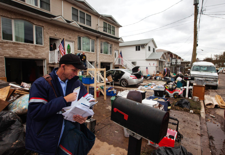 Image: A mailman delivers mail to a neighborhood heavily damaged by Hurricane Sandy in the New Dorp Beach neighborhood of the Staten Island borough of New York
