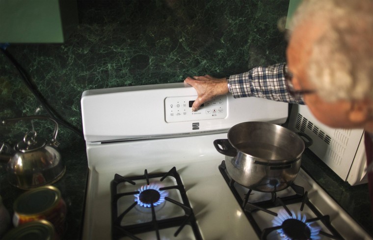 Image: Abrotsky uses his gas stove to heat his 5th floor apartment in a high-rise apartment building that remains devoid of power, heat, and water in the Brighton Beach neighborhood of New York