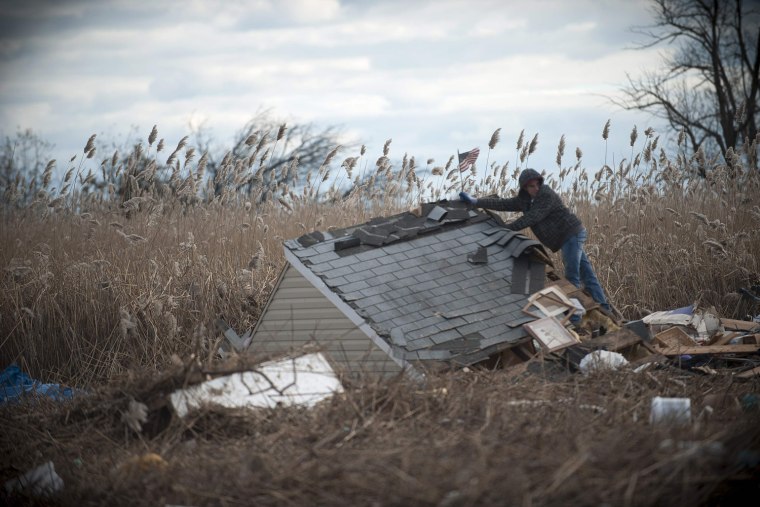Image: A man looks over the remains of a home in the Staten Island Borough of New York
