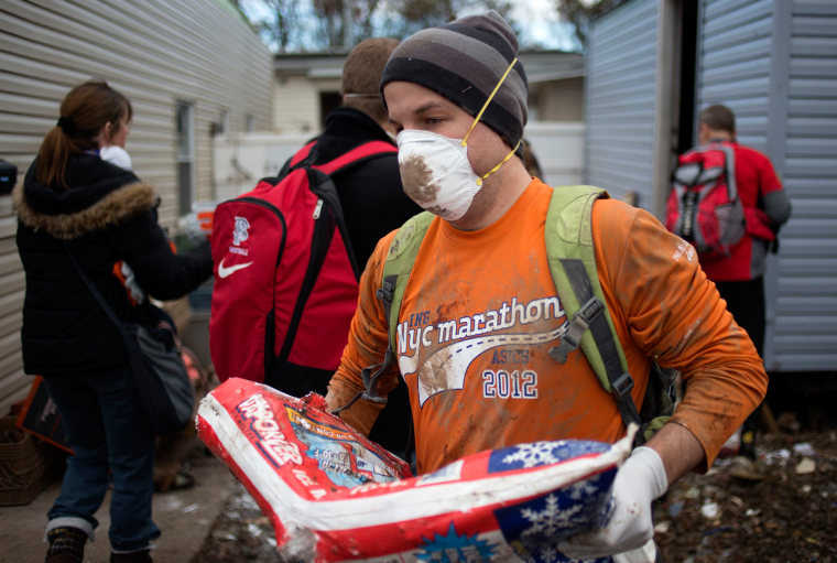 Image: New York City Marathon runners help clear debris from the homes of a damaged neighborhood in the Staten Island borough of New York