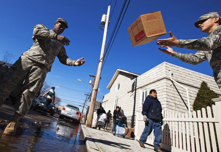 Image: Soldiers from National Guard help to unload supplies to set up donation distribution center for victims of superstorm Sandy at St. Camillus School