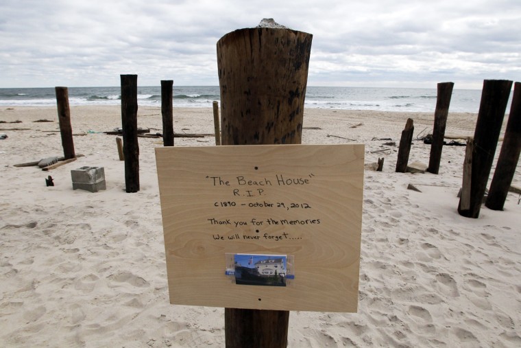 Image: A sign with a photo nailed to one of several pilings all that remains of a house that once stood on this beach-front property in Bay Head