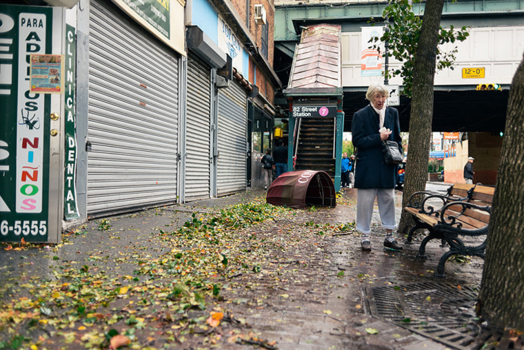 A woman surveying the damage at the corner of 82nd and Roosevelt Avenue. Right after I'd taken this photo she looked at the awning and asked me \"Do you have any idea where that came from?\" I awnsered \"I have no idea\"