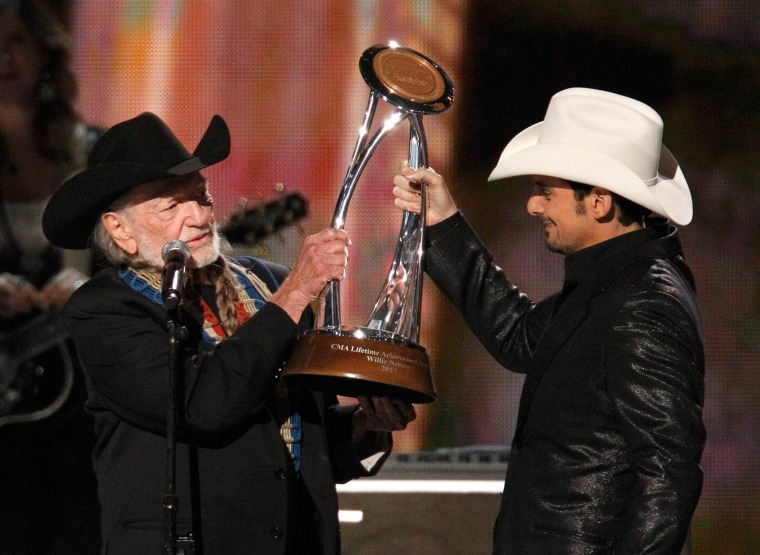 Image: Willie Nelson accepts a lifetime achievement award from Brad Paisley at the 46th Country Music Association Awards in Nashville