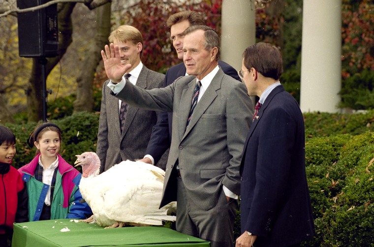 President Bush gestures during a Rose Garden ceremony Tuesday, November 25, 1992 where he pardoned this years Thanksgiving turkey presented by the National Turkey Federation. Chuck Helms, left, and Bruce Cuddy stand behind Bush. (AP Photo/Greg Gibson)