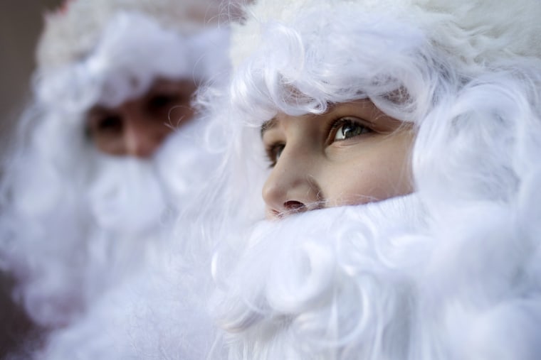 Image: Volunteers are seen in Santa suits before they march through Midtown Manhattan during the Volunteers of America's 110th Annual Sidewalk Santa Parade in New York