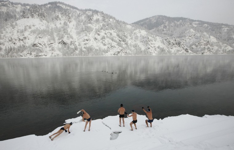 Image: Members of local winter swimming club warm up on bank of Yenisei River ahead of their weekly bathing session, while air temperatures stand at minus 17 degrees Celsius, in town of Divnogorsk