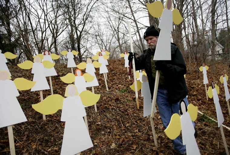 Image: Eric Mueller places 27 wooden painted angels outside his home in Newtown, Connecticut