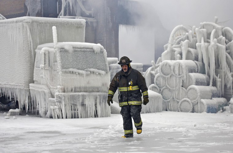 Image: Chicago Fire Department Lieutenant De Jesus walks around an ice-covered warehouse that caught fire Tuesday night in Chicago
