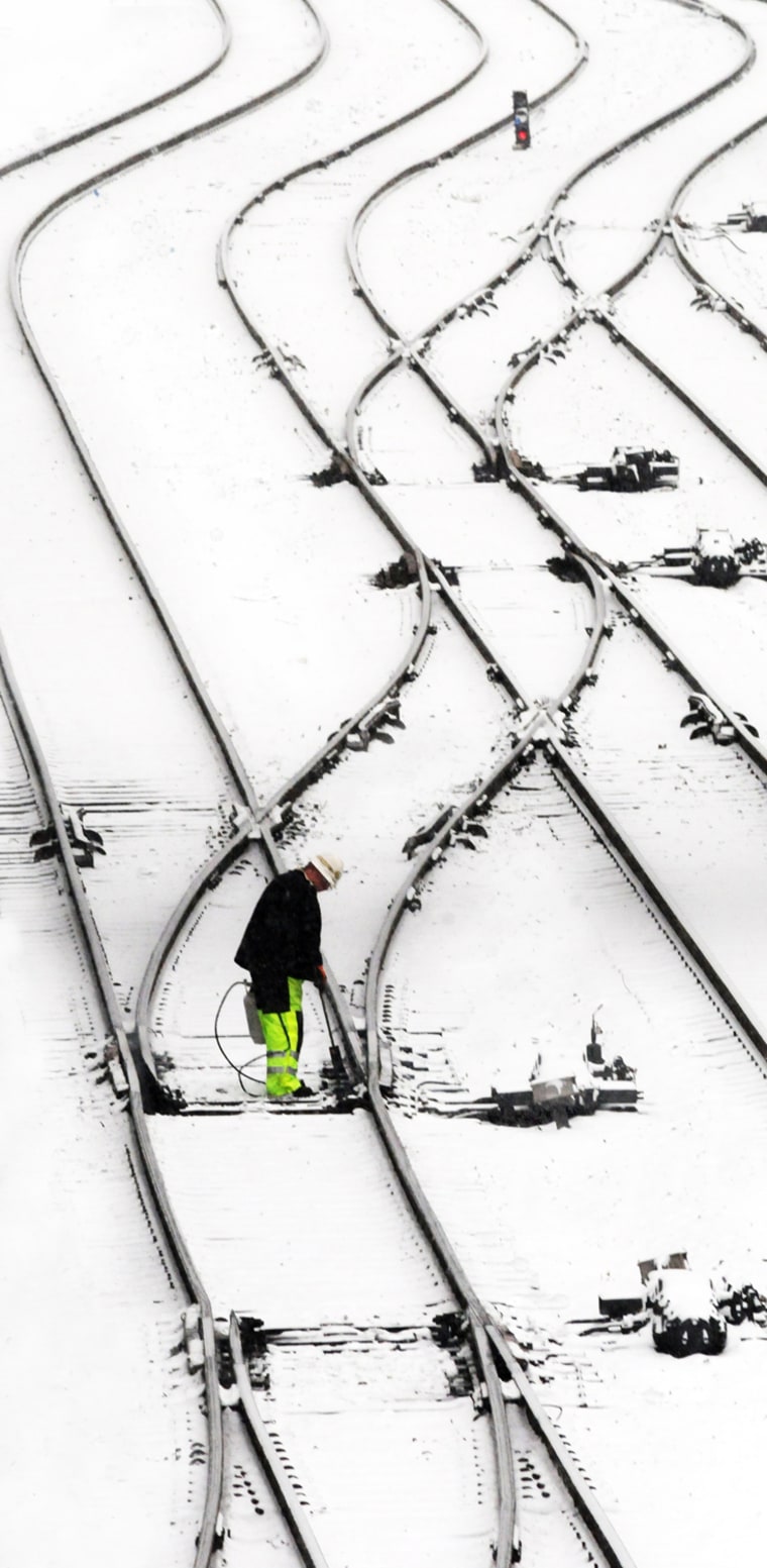 Image: Railyard signalman Phil Smith uses a portable propane torch to thaw the track switches