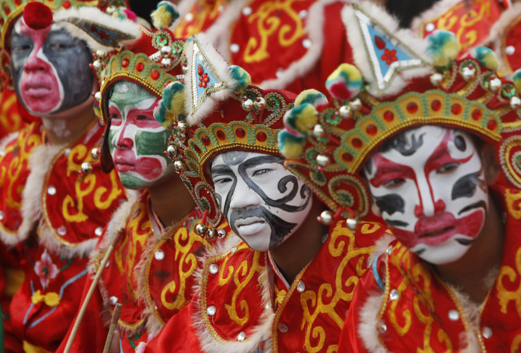 Image: Traditional Chinese dancers wait to perform ahead of the Chinese Lunar New Year celebrations in Suphan Buri province