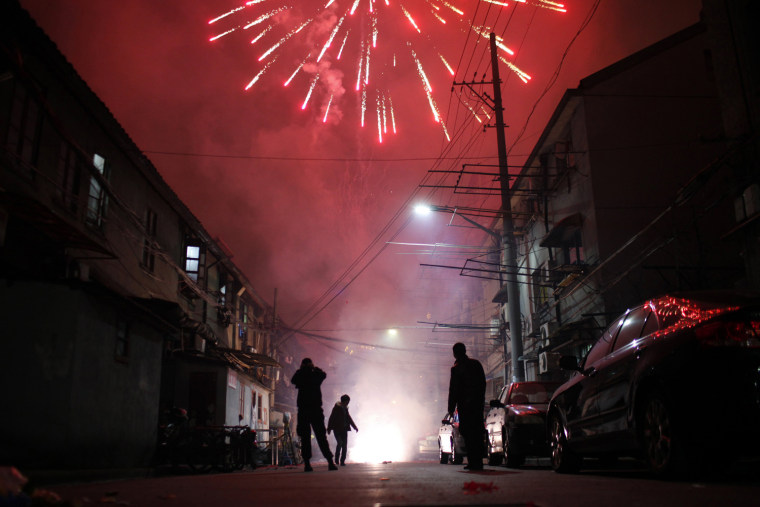 Image: Men light up fireworks as residents celebrate the start of the Chinese New Year in Shanghai