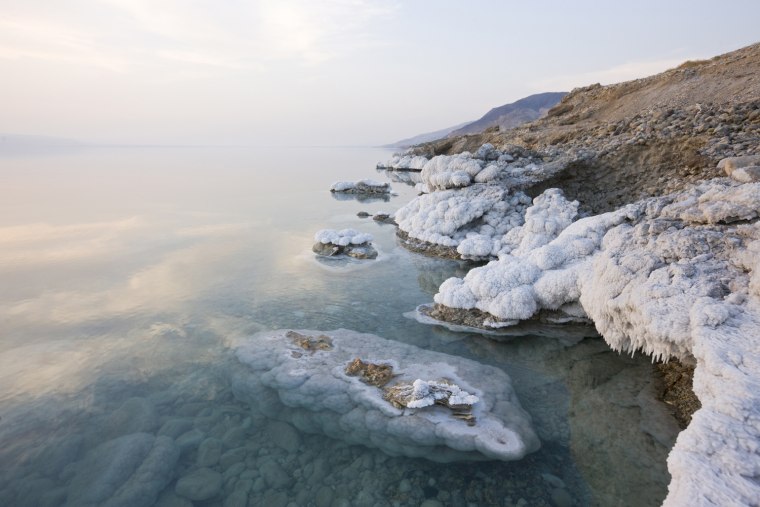 Jordanian shore of the Dead Sea near Zara spring, where waves have left a thick layer of salt crystals and stalactites.