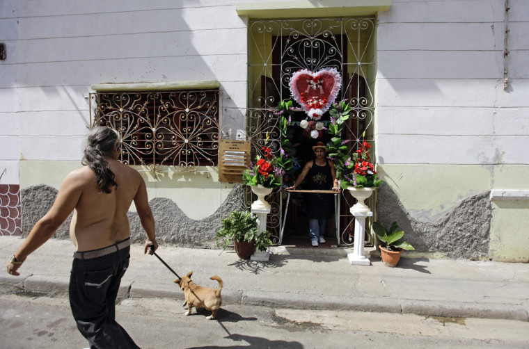 Image: A man waits for customers to buy his flower arrangements as Valentine's Day gifts at his stall in Havana