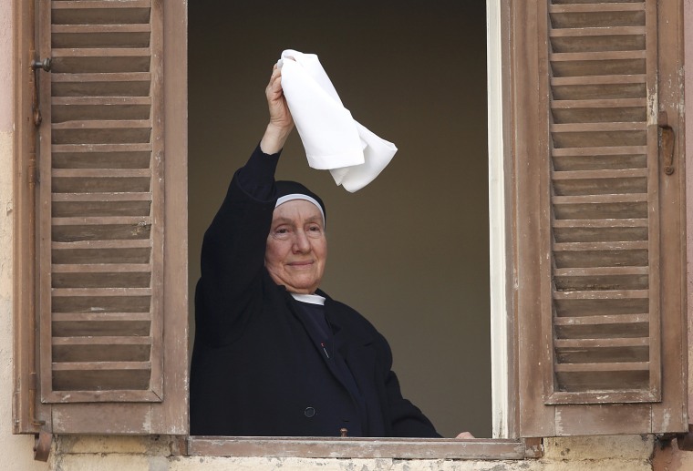 Image: A nun waves her handkerchief from a window as Pope Benedict XVI makes his final address at Castelgandolfo