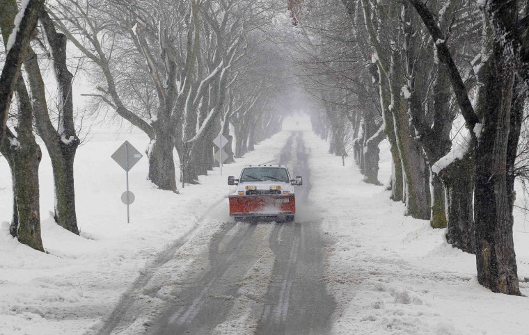 Image: A snowplow moves down a country lane during a massive blizzard near Mt. Jackson, Virginia