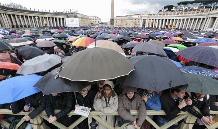 Image: Faithful shelter from rain while waiting for smoke to rise from a chimney on top of the Sistine Chapel during the second day of voting for the election of a new pope at the Vatican