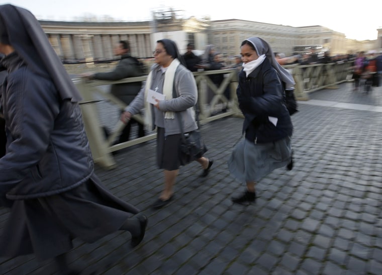 Image: Nuns run in Saint Peter's Square to take a good vantage point before the inaugural mass for Pope Francis at the Vatican