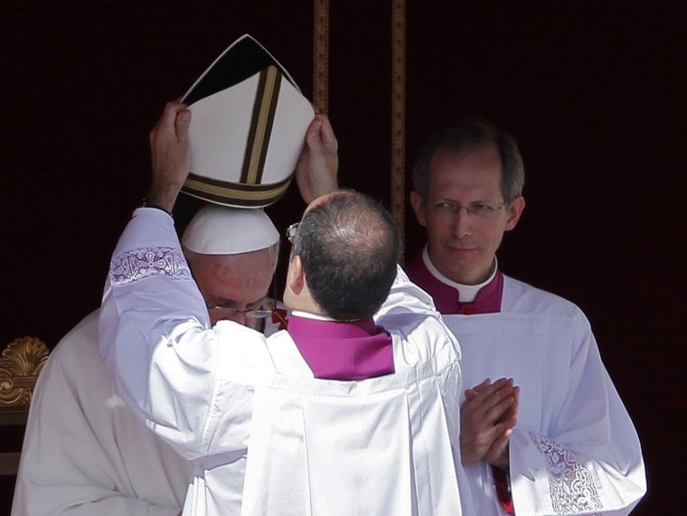 Image: The papal mitre is placed on the head of Pope Francis during his inaugural mass in Saint Peter's Square at the Vatican