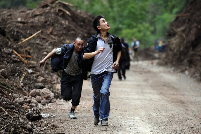 Image: People running during earthquake aftershocks to avoid falling rocks on their way to the city of Ya'an, in China's Sichuan province.