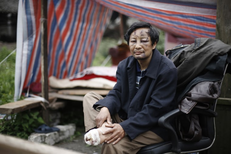 Image: A survivor sits outside a tent after Saturday's earthquake in Lingguan town of Baoxing county, Sichuan province