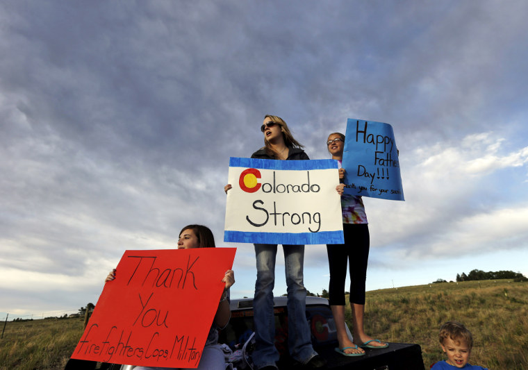 Image: From left, Black Forest resident Kristin Brown, whose family lost their home in the wildfire, is joined by Ashley Clipp, Kaitlyn Barlow and Ashley's son Jackson, 2, as they support first responders outside of a fire camp in Colorado Springs, Colo., on Sunday.