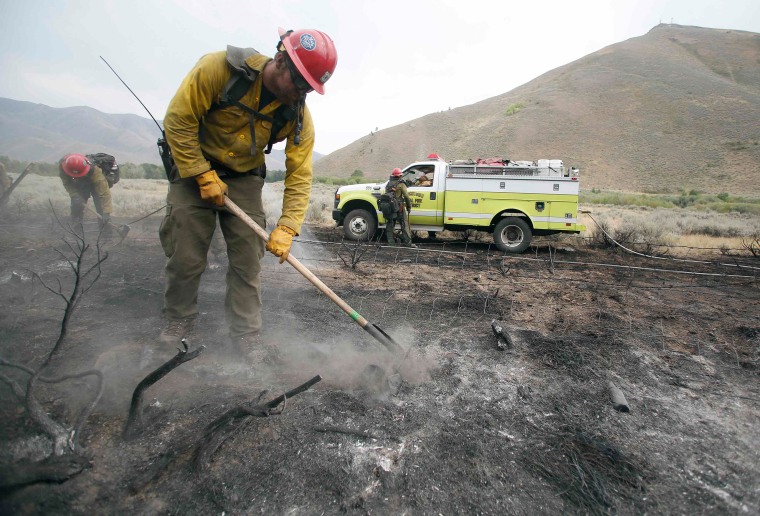 Image: Firefighters clear a burned area at the Beaver Creek wildfire outside Hailey