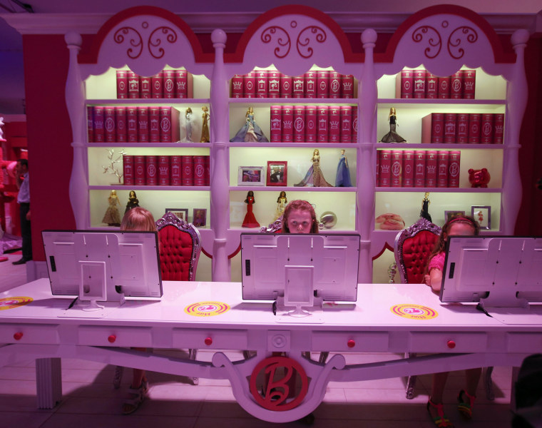 Image: Six years old Lara plays with a computer inside a \"Barbie Dreamhouse\" of Mattel's Barbie dolls in Berlin