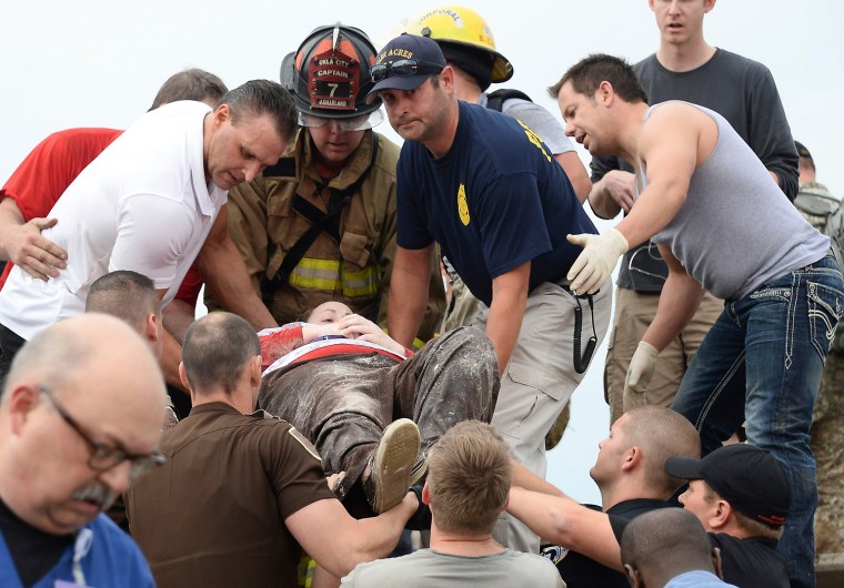Image: Rescue workers help free one of the 15 people that were trap at a medical building at the Moore hospital complex in Moore