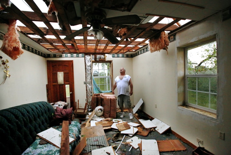 Wesley Little looks through the large opening in the roof of his home's family room after a tornado hit the area. Little and his wife, Barbara, have lived in this him e for 25 years. Wesley and Barbara took shelter in their home's basement with 6 other people, including his mother, Emma McAdams,  and four dogs. A tornado caused extensive damage along I-40 at the junction with  US 177 on the west side of Shawnee Sunday evening,  May 19,  2013.  Photo  by Jim Beckel, The Oklahoman.