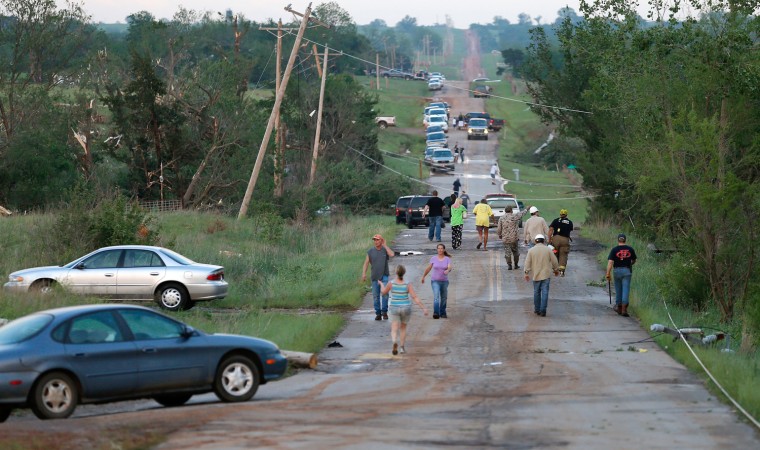 Residents walk down a street in Carney, Okla., after a tornado swept through the area on Sunday, May 19, 2013. Photo by Bryan Terry, The Oklahoman